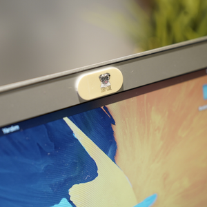 Sarı üzerinde pug resmi ve stay cool yazan kamera kapatıcı laptop kamerasına takılmış
