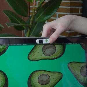 beyaz üzerinde spor yapan avokado görseli olan kamera kapatıcısı avokado görselli laptopa takılmış